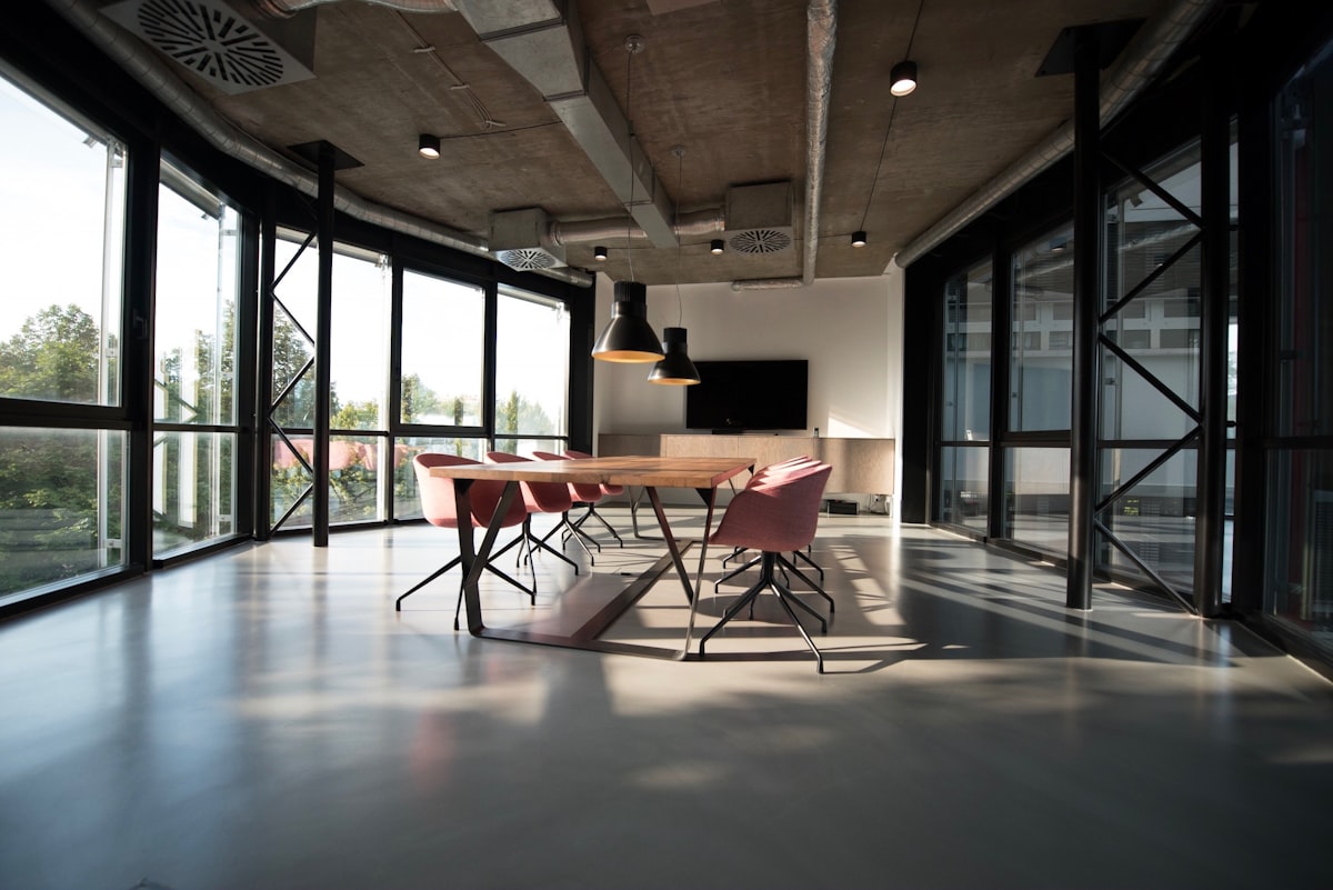 An empty office corridor with glass-walled meeting rooms